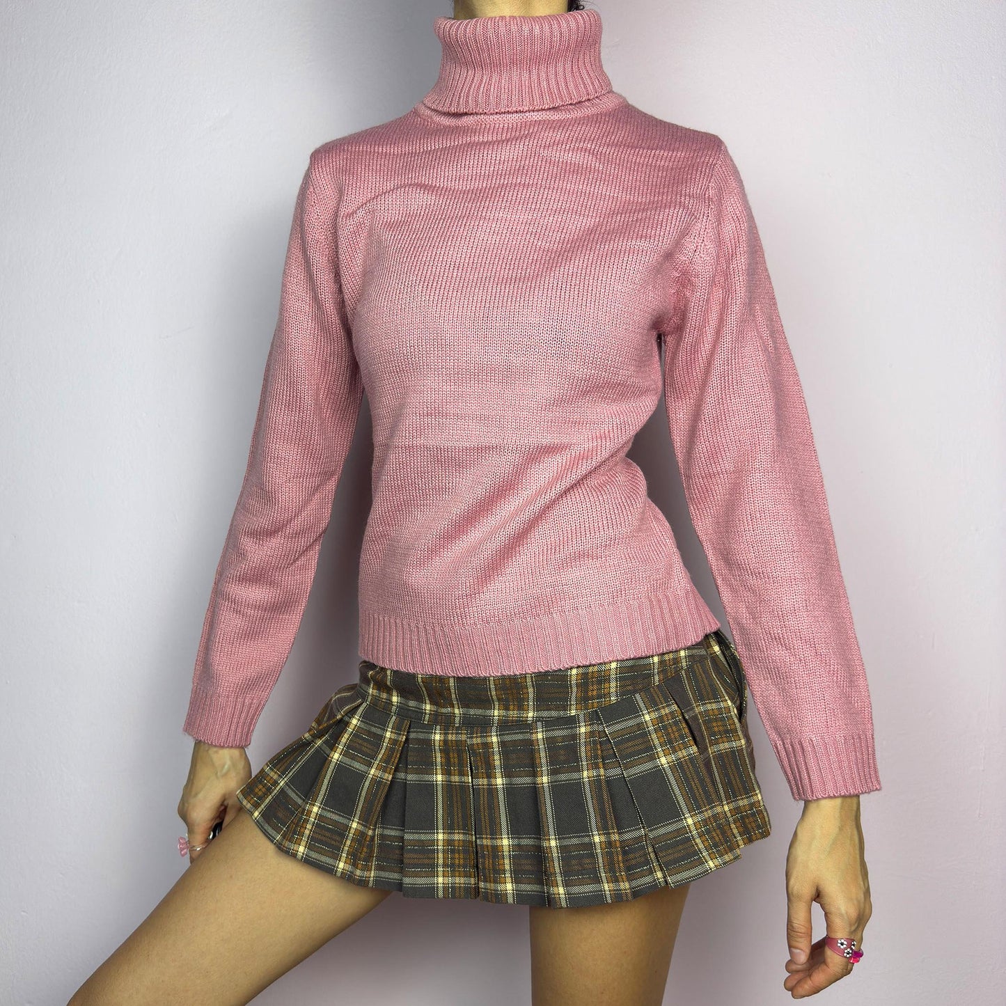 This Y2K Pink Turtleneck Sweater is a cozy 2000s essential with a minimalist vintage aesthetic. Crafted from a soft, knit fabric in a muted pastel pink, it features a classic high turtleneck, a fitted silhouette for a flattering look and long sleeves with ribbed cuffs. Ideal for casual or preppy winter styles. adult world shop