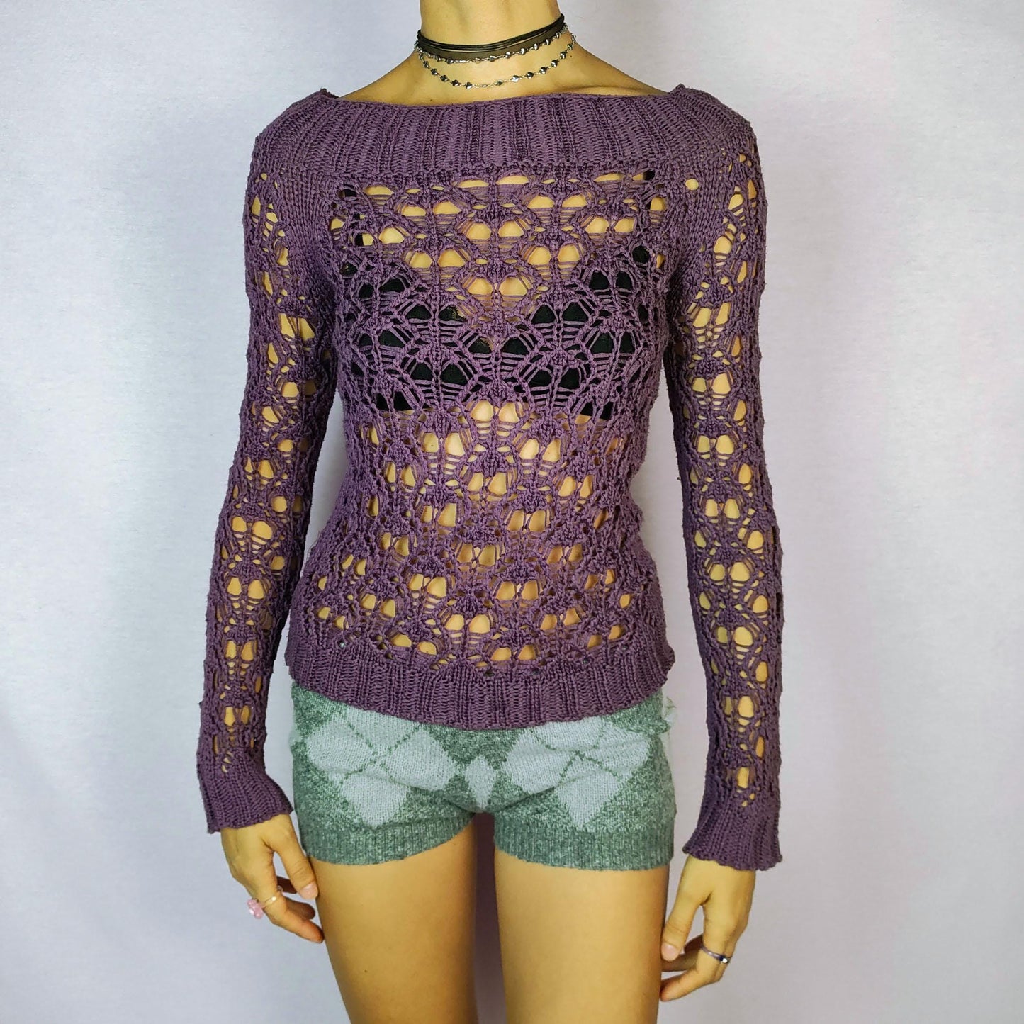 The Y2K Purple Crochet Boat Sweater is a vintage 2000s pullover featuring an intricate crochet-knit design, a boat neckline and long sleeves.