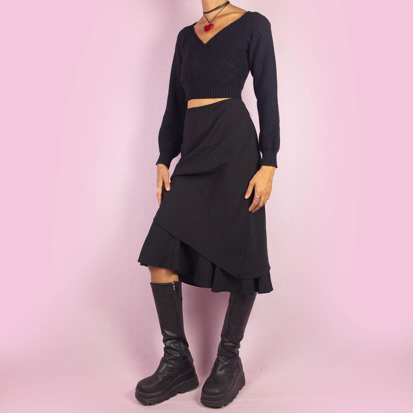 The Vintage 90s Black Layered Midi Skirt showcases a layered design with a flared underlayer peeking out for an elegant silhouette. Featuring an elastic waist, this midi-length skirt is perfect for both office wear and evening occasions.