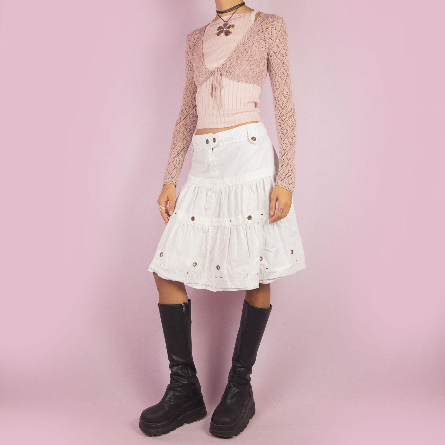 The Y2K White Tiered Midi Skirt is a vintage 2000s piece featuring a playful tiered design, button details, and a front zipper closure. Perfect for summer outings or casual daytime looks.