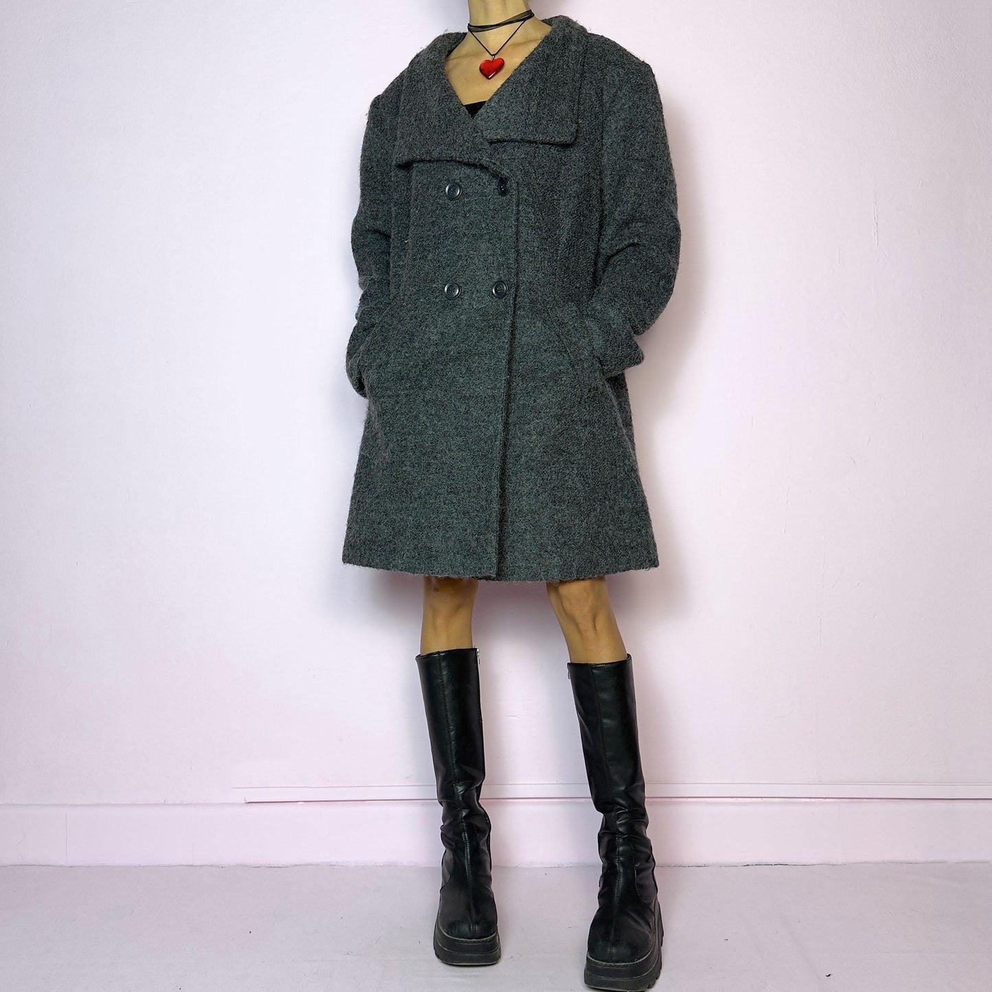 The Y2K Gray Wool Coat is a vintage 2000s timeless piece crafted from a soft and warm wool and polyester blend. It features a double-breasted front with oversized buttons, a wide lapel collar, and side pockets for a cozy design. Its relaxed fit