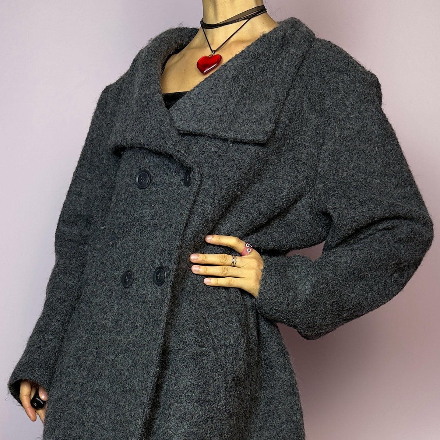 The Y2K Gray Wool Coat is a vintage 2000s timeless piece crafted from a soft and warm wool and polyester blend. It features a double-breasted front with oversized buttons, a wide lapel collar, and side pockets for a cozy design. Its relaxed fit