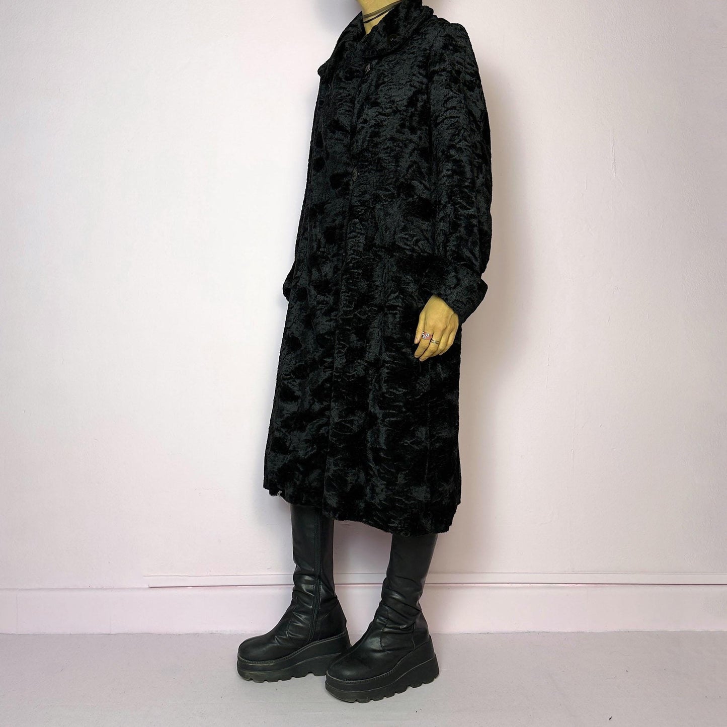 The Vintage 90s Black Faux Fur Long Coat features a plush faux fur exterior for a cozy feel. Designed with a button front closure, it includes long sleeves and pockets. Its longline silhouette makes it a chic and warm choice for winter evenings