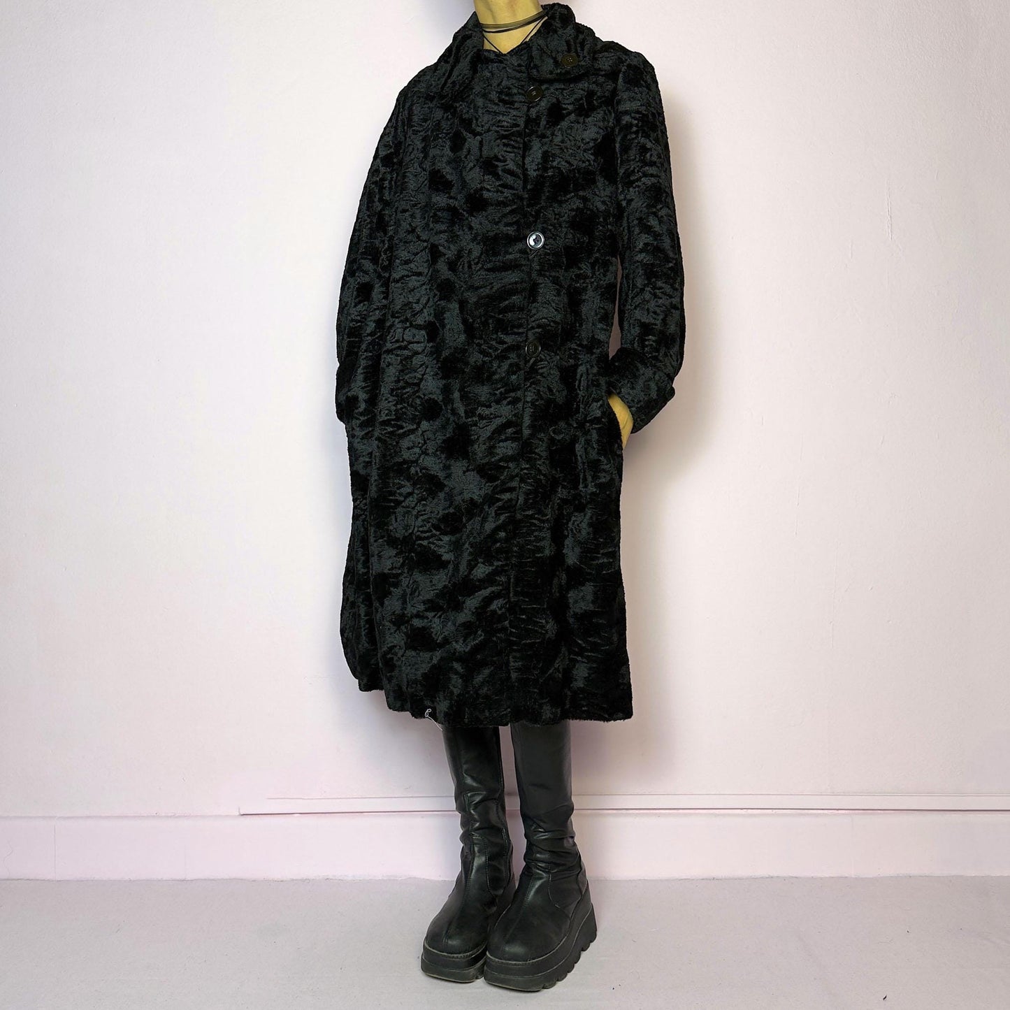 The Vintage 90s Black Faux Fur Long Coat features a plush faux fur exterior for a cozy feel. Designed with a button front closure, it includes long sleeves and pockets. Its longline silhouette makes it a chic and warm choice for winter evenings