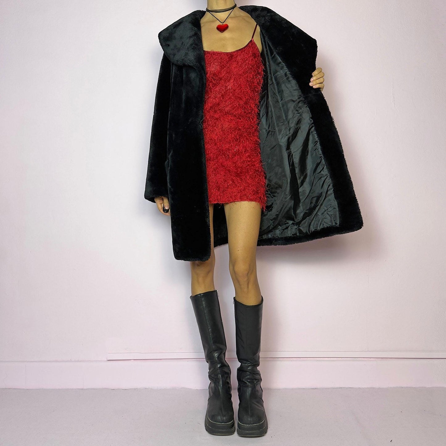 The Vintage 90s Black Faux Fur Coat showcases a faux fur material for a sophisticated and cozy winter style. It features a plush oversized collar, a chic fabric-covered button closure, and pockets. Perfect for winter outings or evening events.
