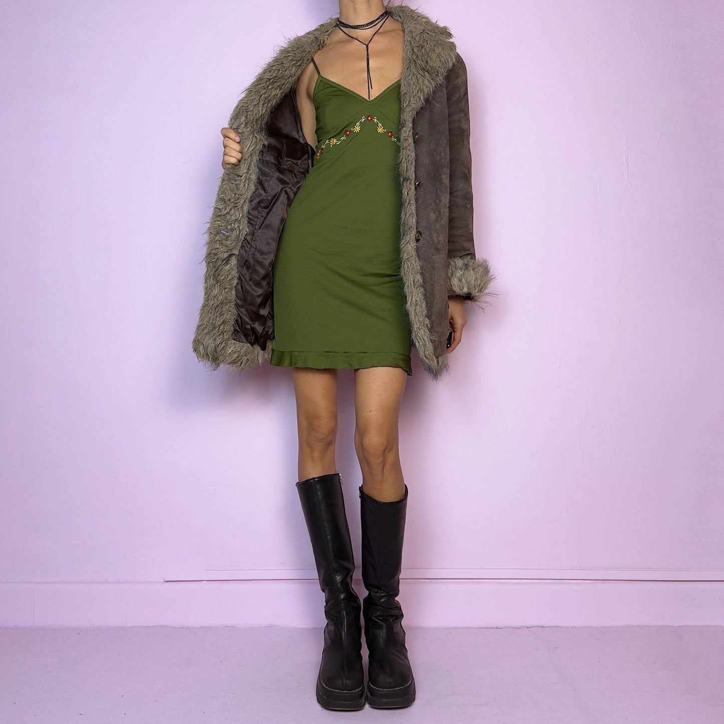 The Vintage 90s Brown Suede Penny Lane Coat showcases a brown leather suede finish paired with soft faux fur trims along the collar, cuffs, and hemline. This jacket features button closures and intricate stitch details. Its timeless design