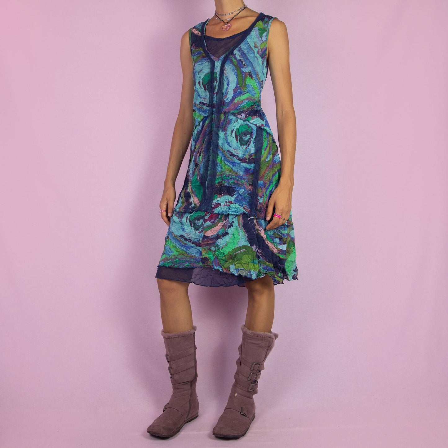 The Y2K Art Print Mesh Dress is a vintage 2000s piece featuring a flowing A-line silhouette with an abstract, artistic print in vibrant tones of blue, green, and purple. Crafted from lightweight, semi-sheer mesh fabric, it offers a layered design