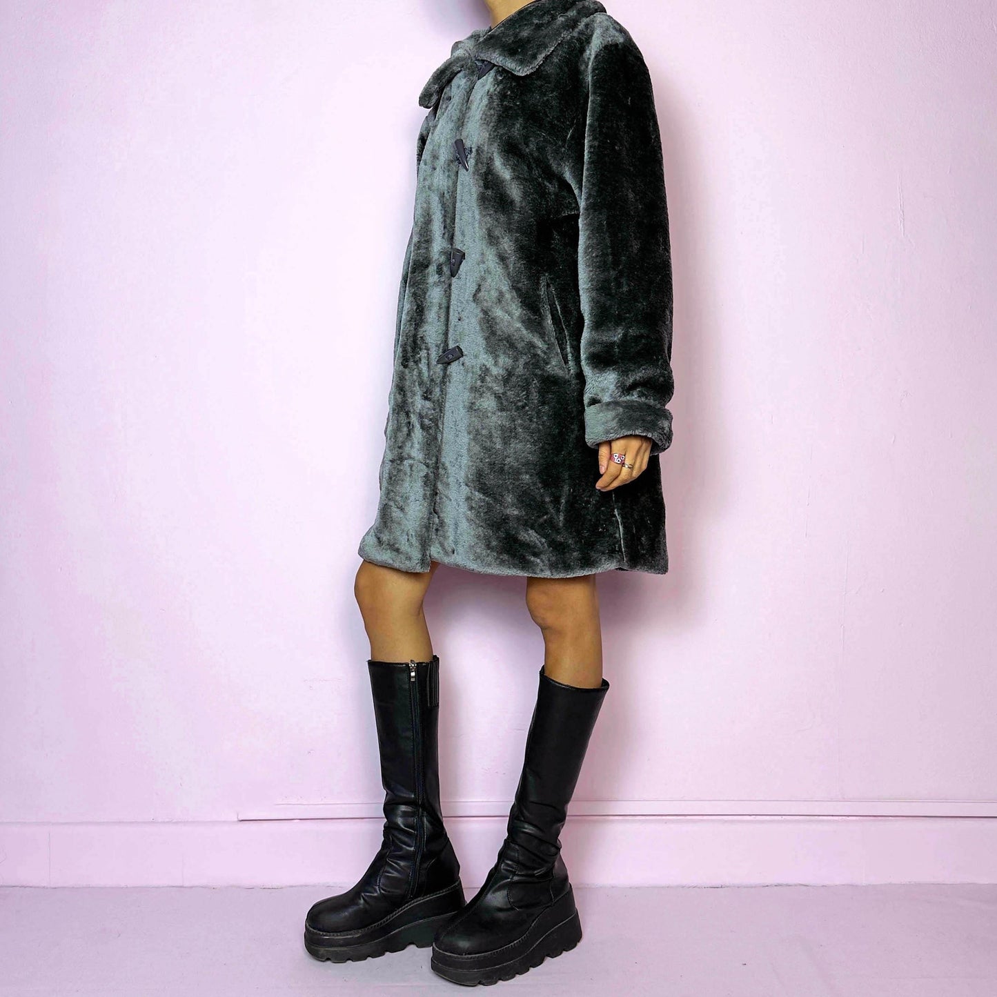 The Vintage 90s Gray Faux Fur Coat is a cozy and stylish outerwear piece featuring a plush faux fur design, a toggle-front closure, a wide collar, and pockets. Perfect for your winter wardrobe.
