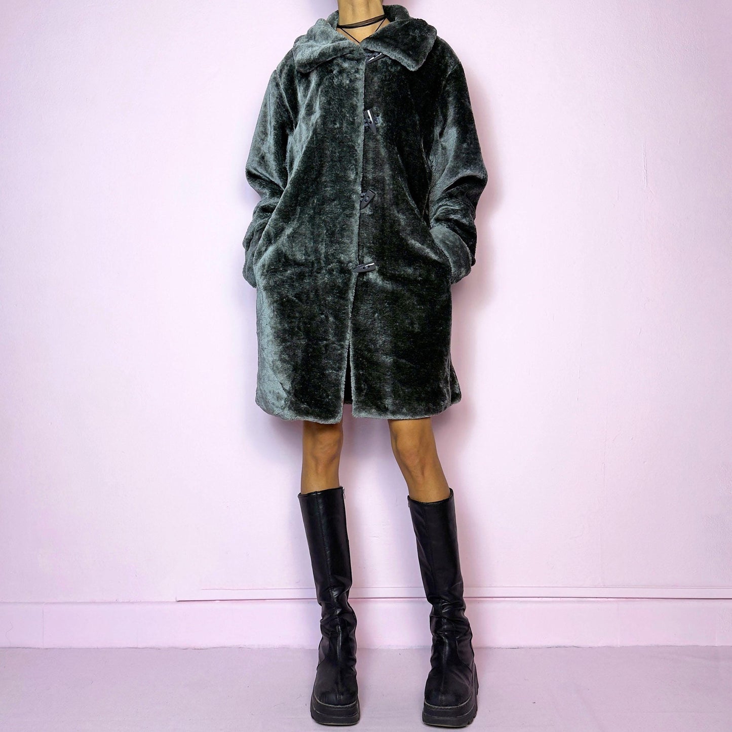 The Vintage 90s Gray Faux Fur Coat is a cozy and stylish outerwear piece featuring a plush faux fur design, a toggle-front closure, a wide collar, and pockets. Perfect for your winter wardrobe.