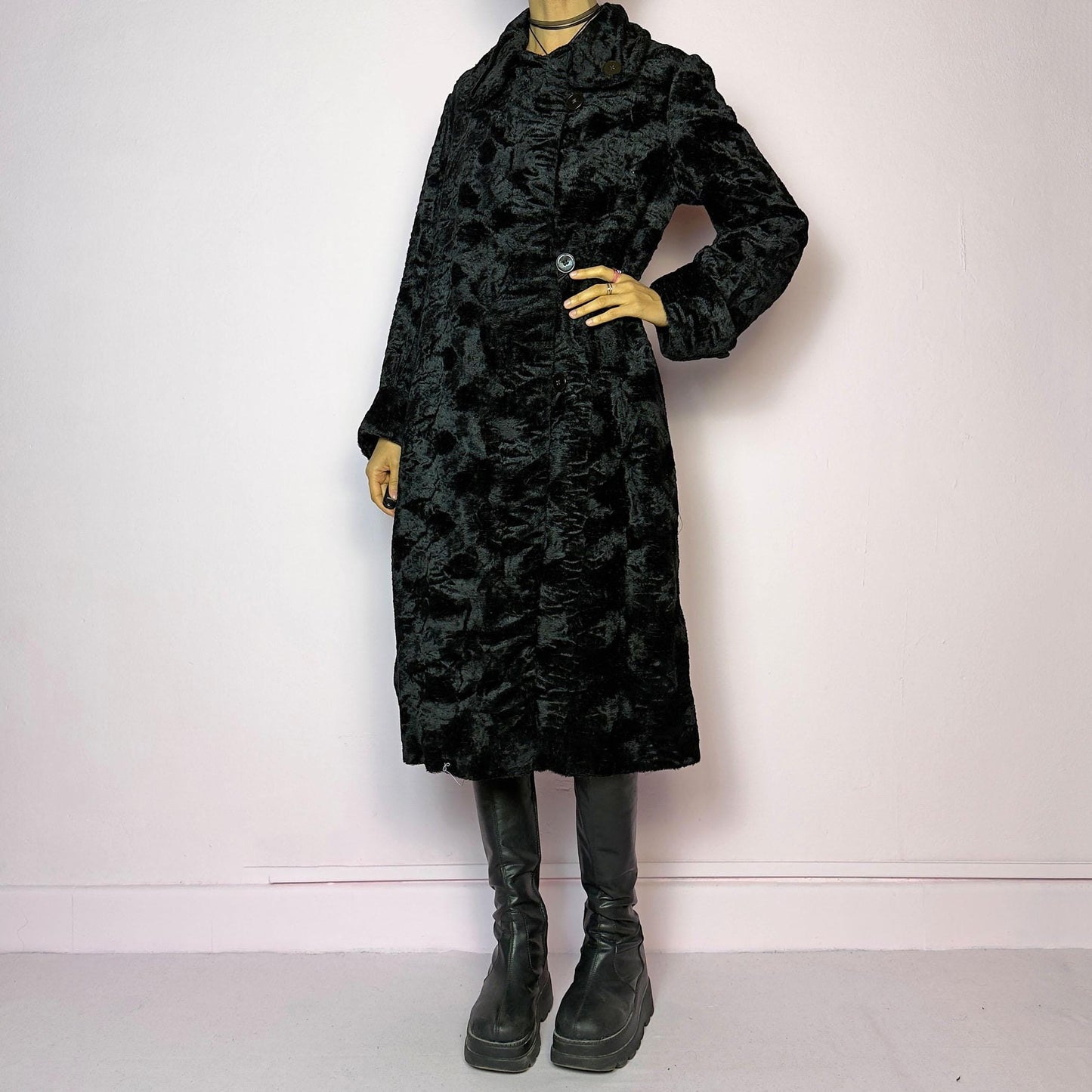 The Vintage 90s Black Faux Fur Long Coat features a plush faux fur exterior for a cozy feel. Designed with a button front closure, it includes long sleeves and pockets. Its longline silhouette makes it a chic and warm choice for winter evenings