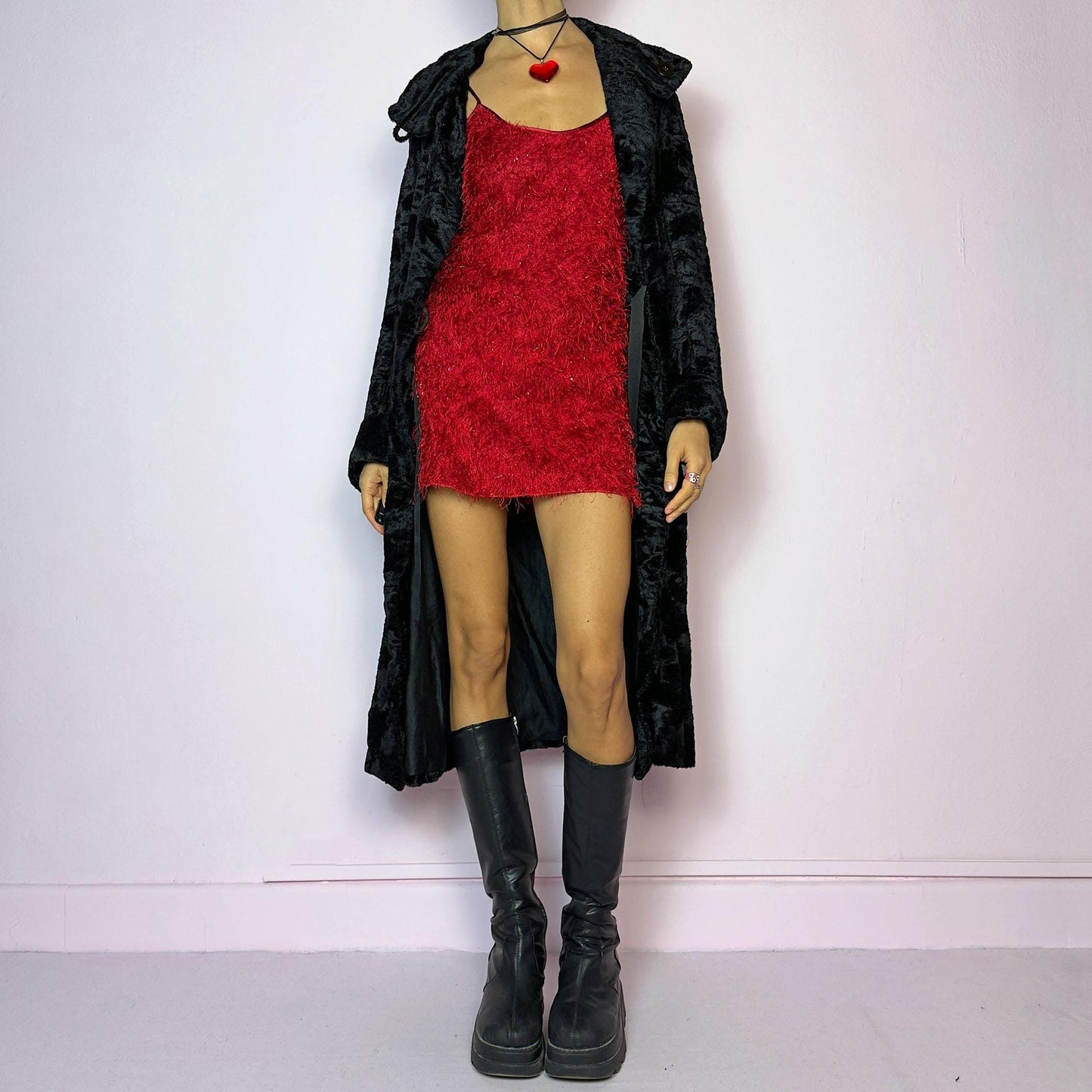 The Vintage 90s Black Faux Fur Long Coat features a plush faux fur exterior for a cozy feel. Designed with a button front closure, it includes long sleeves and pockets. Its longline silhouette makes it a chic and warm choice for winter evenings