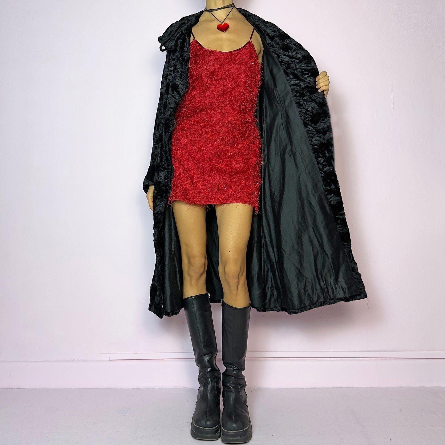 The Vintage 90s Black Faux Fur Long Coat features a plush faux fur exterior for a cozy feel. Designed with a button front closure, it includes long sleeves and pockets. Its longline silhouette makes it a chic and warm choice for winter evenings