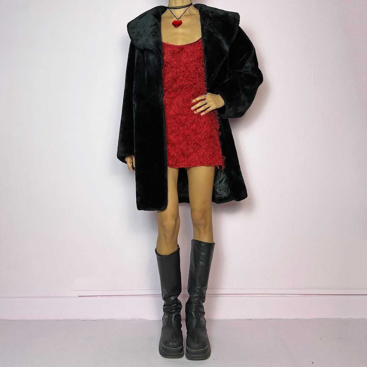 The Vintage 90s Black Faux Fur Coat showcases a faux fur material for a sophisticated and cozy winter style. It features a plush oversized collar, a chic fabric-covered button closure, and pockets. Perfect for winter outings or evening events.