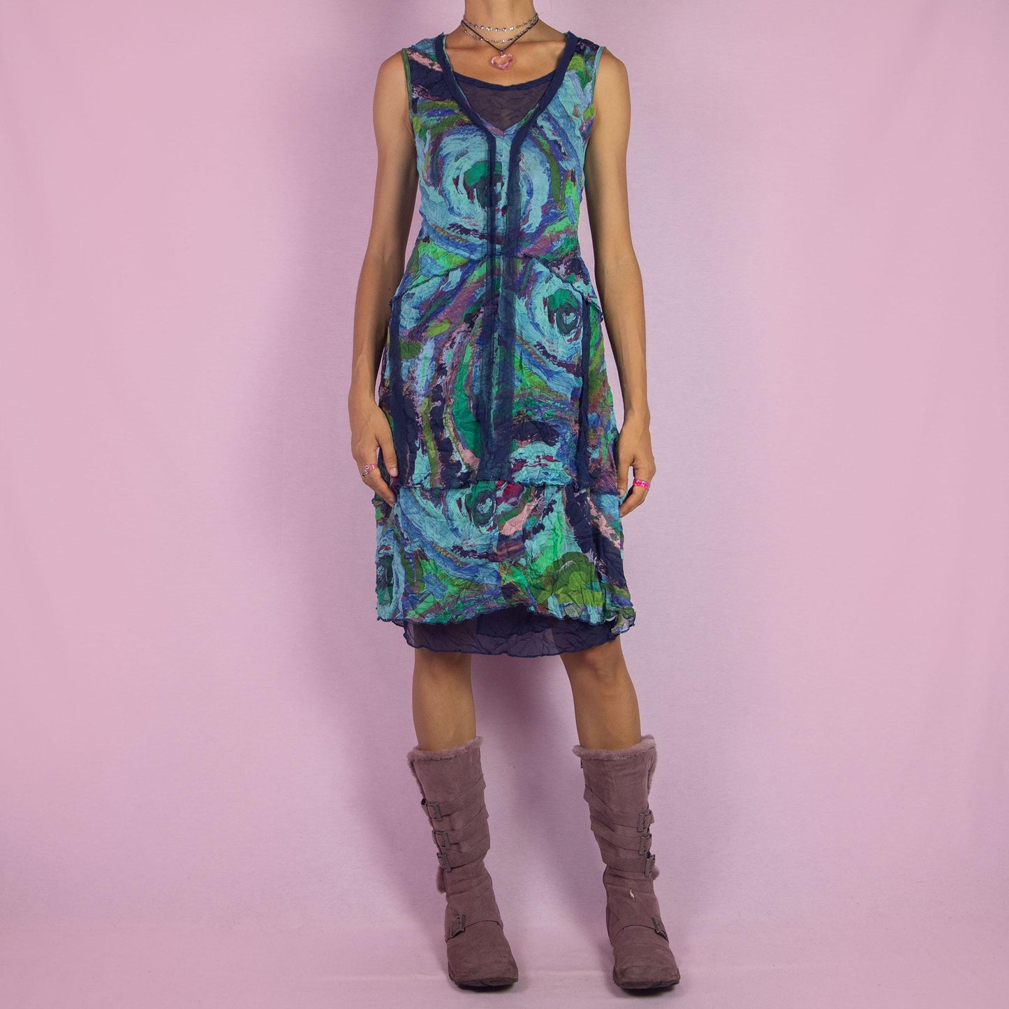 The Y2K Art Print Mesh Dress is a vintage 2000s piece featuring a flowing A-line silhouette with an abstract, artistic print in vibrant tones of blue, green, and purple. Crafted from lightweight, semi-sheer mesh fabric, it offers a layered design