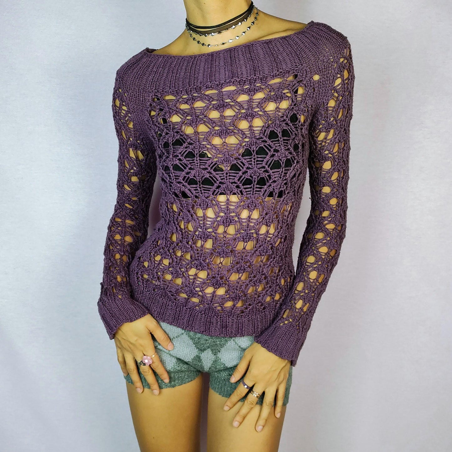 The Y2K Purple Crochet Boat Sweater is a vintage 2000s pullover featuring an intricate crochet-knit design, a boat neckline and long sleeves.