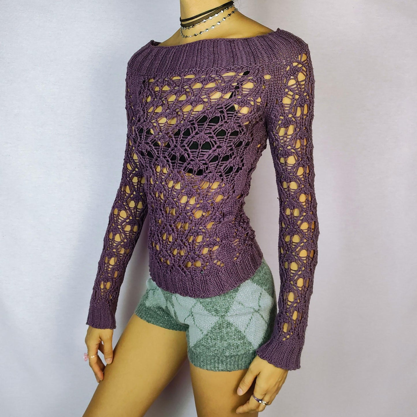 The Y2K Purple Crochet Boat Sweater is a vintage 2000s pullover featuring an intricate crochet-knit design, a boat neckline and long sleeves.
