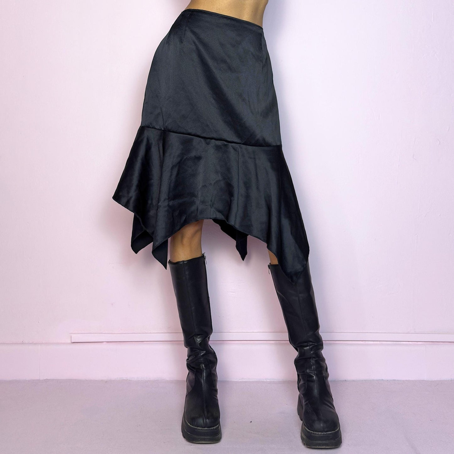 The Y2K Black Satin Asymmetric Skirt is a vintage 2000s stylish piece, featuring a satin-like finish with an asymmetrical handkerchief hemline for a dramatic flair and a size zipper closure. Perfect choice for party nights. Adult World Shop