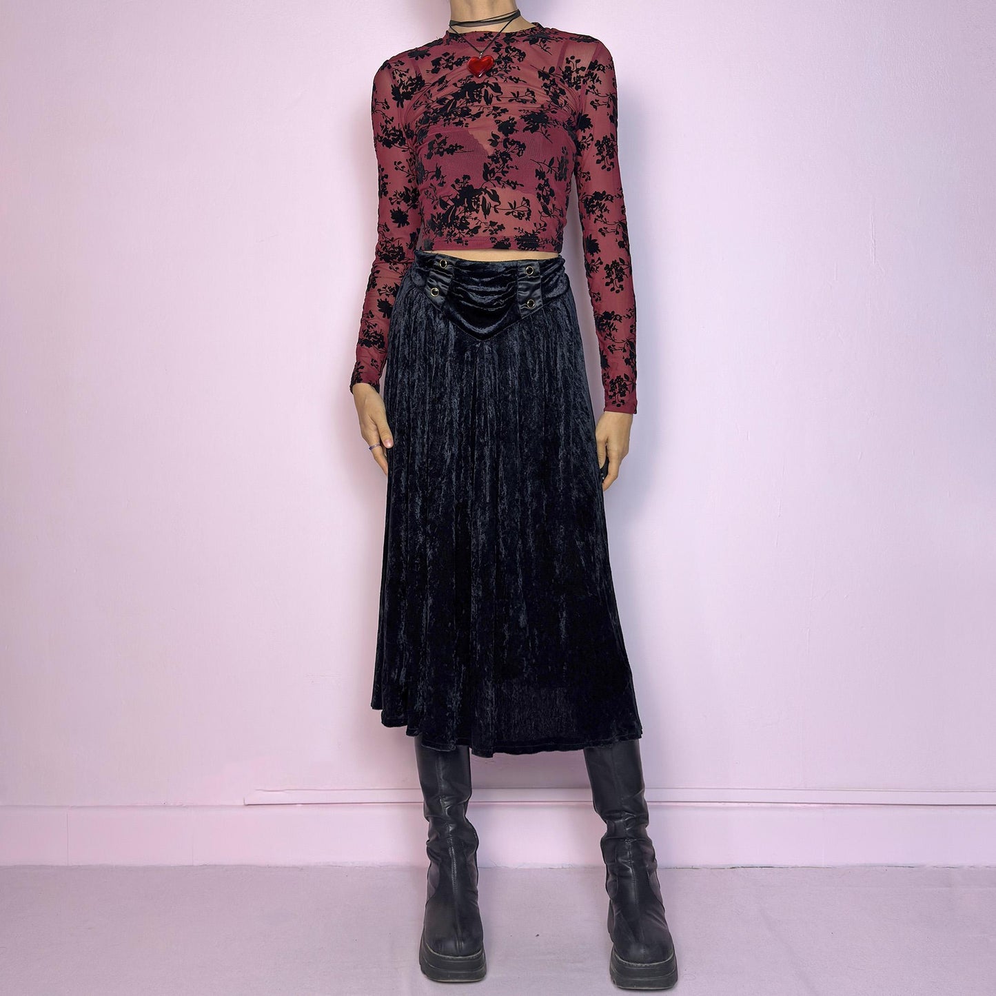 The Vintage 90s Black Velvet Midi Skirt is crafted from soft velvet and features an elastic waistband detail with button accents and a flowing A-line silhouette. Ideal for night parties and embodies a whimsical goth aesthetic. Adult World Shop