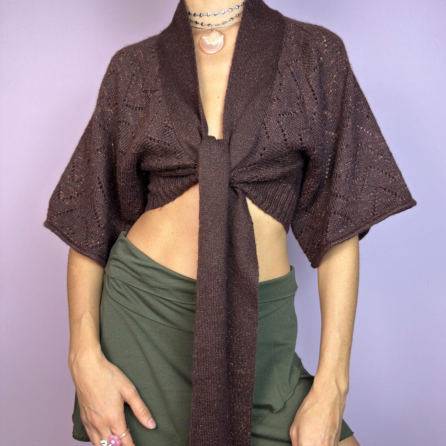 The Y2K Brown Knit Cardigan Bolero is a chic vintage 2000s piece. This cropped bolero features an open-knit design, short sleeves, and a long tie-front closure for an adjustable fit. Its warm brown tone. adult world shop