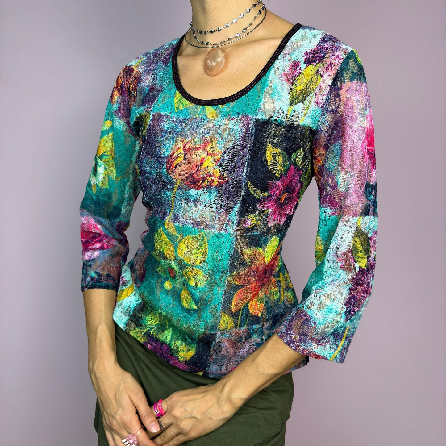 The Y2K Painting Lace Mesh Top is a vintage 2000s artistic statement piece. Featuring a semi-sheer lace fabric adorned with a bold, vibrant floral pattern resembling a painterly masterpiece, a scoop neckline and 3/4 sleeves. adult world shop