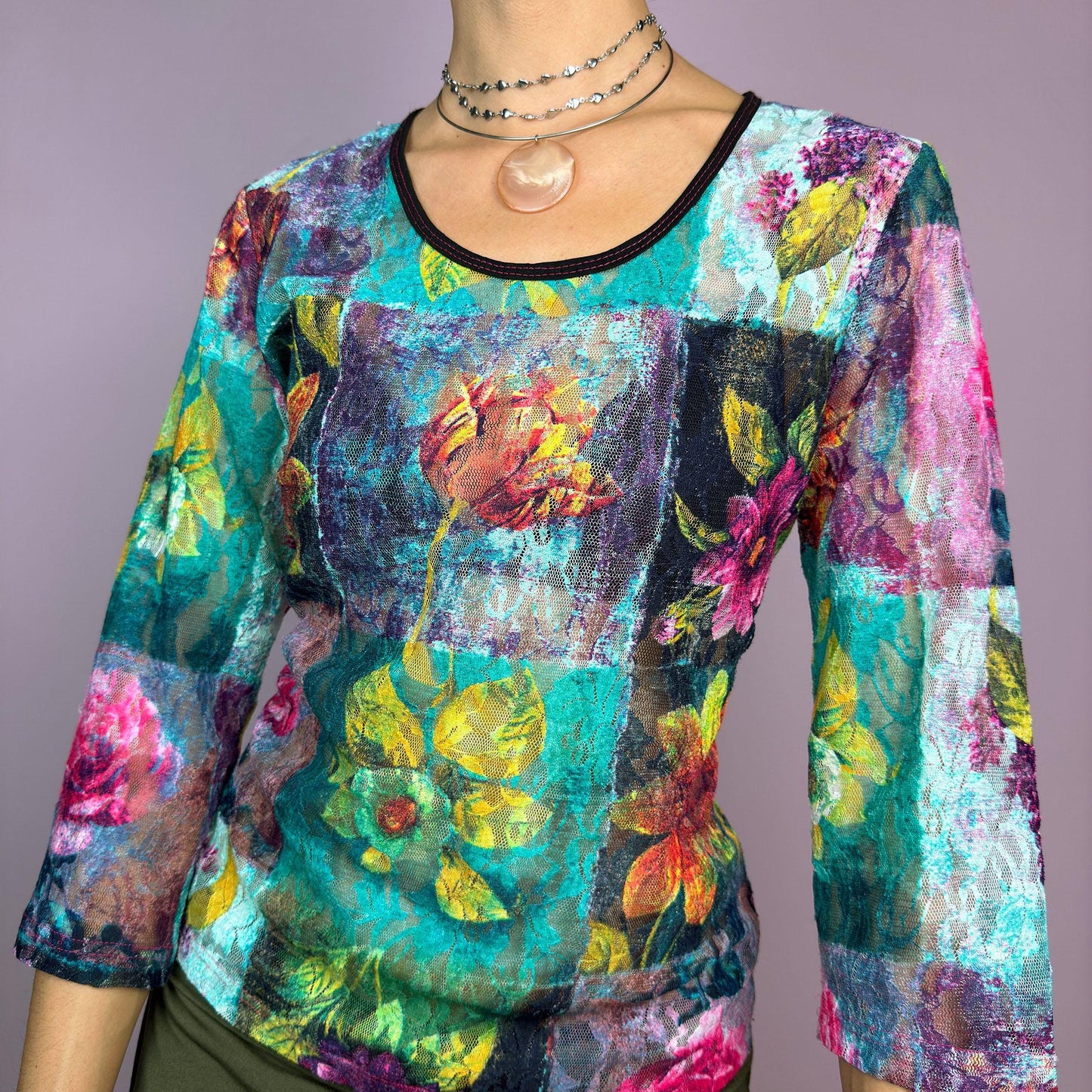 The Y2K Painting Lace Mesh Top is a vintage 2000s artistic statement piece. Featuring a semi-sheer lace fabric adorned with a bold, vibrant floral pattern resembling a painterly masterpiece, a scoop neckline and 3/4 sleeves. adult world shop