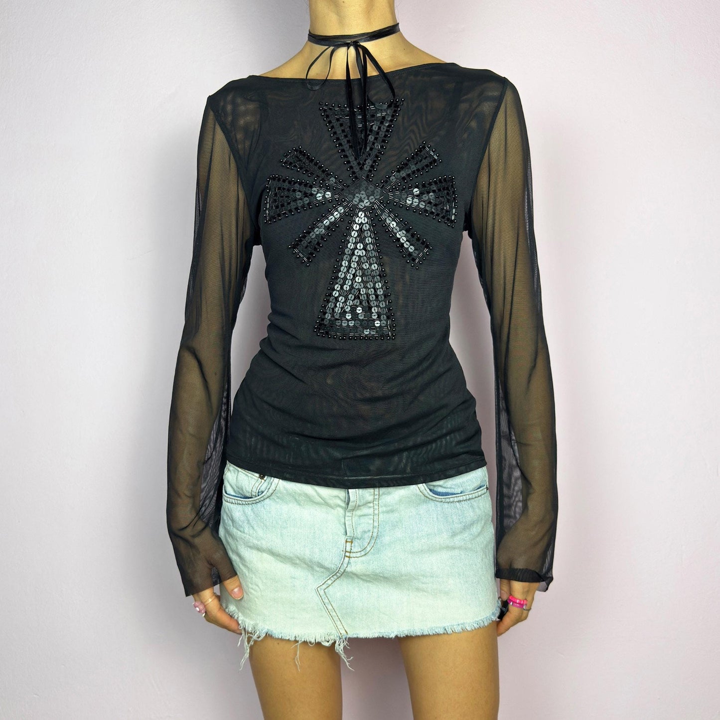 The Y2K Black Embellished Mesh Top is a statement vintage 2000s piece. This sheer top features a bold black sequin and bead embellishment in a striking cross pattern on the front. The lightweight mesh fabric and long sleeves. adult world shop