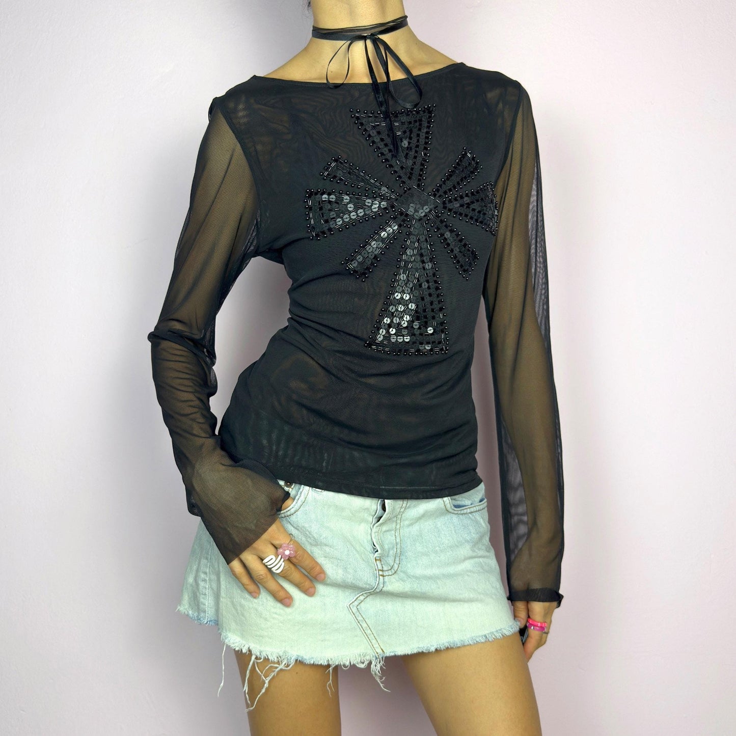 The Y2K Black Embellished Mesh Top is a statement vintage 2000s piece. This sheer top features a bold black sequin and bead embellishment in a striking cross pattern on the front. The lightweight mesh fabric and long sleeves. adult world shop