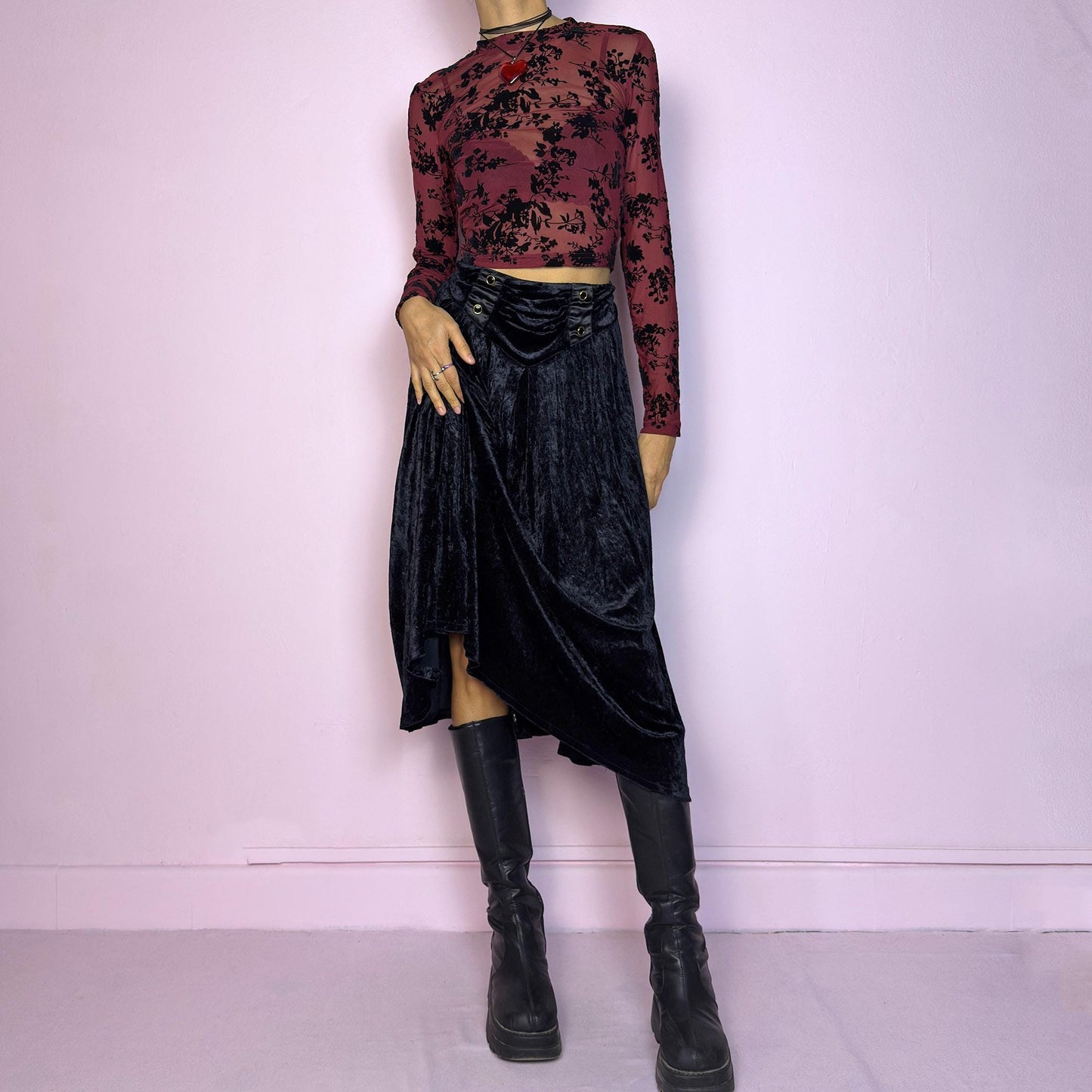 The Vintage 90s Black Velvet Midi Skirt is crafted from soft velvet and features an elastic waistband detail with button accents and a flowing A-line silhouette. Ideal for night parties and embodies a whimsical goth aesthetic. Adult World Shop
