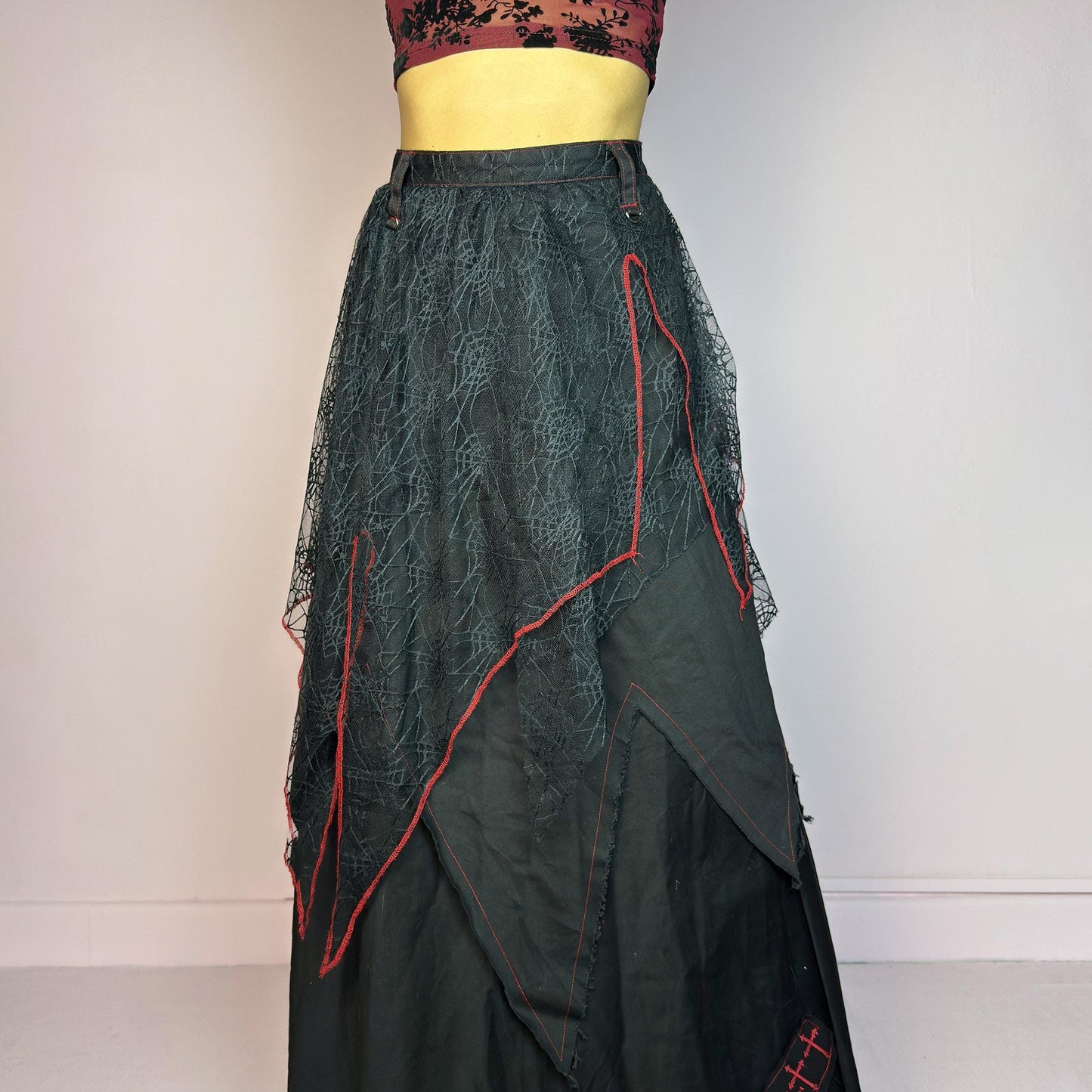 The Black Layered Maxi Skirt is a vintage edgy statement piece crafted by the Japanese punk fashion brand RIGHT? Anarchxism = Kexstation. It features a multi-layered design with mesh web-like overlays, bold red stitching details. Adult World Shop