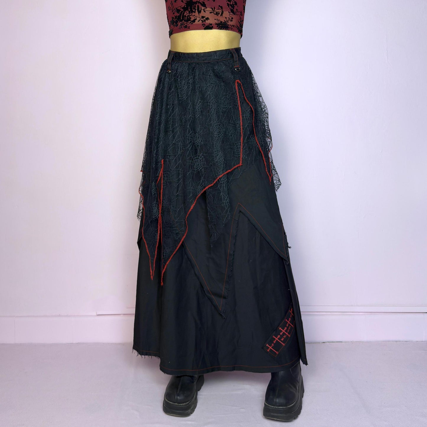 The Black Layered Maxi Skirt is a vintage edgy statement piece crafted by the Japanese punk fashion brand RIGHT? Anarchxism = Kexstation. It features a multi-layered design with mesh web-like overlays, bold red stitching details. Adult World Shop