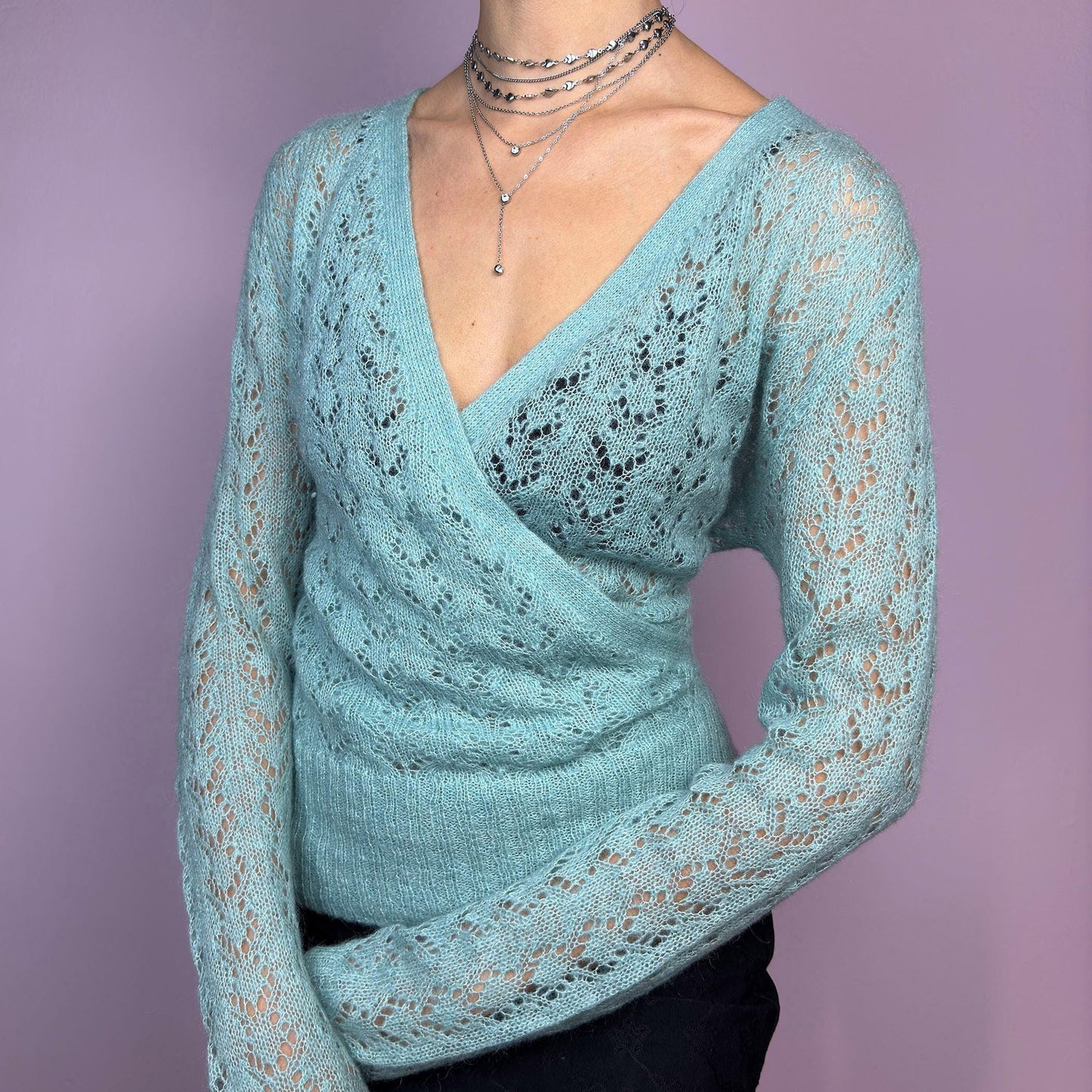 The Y2K Blue Wrap Tie Cardigan is a soft and delicate vintage 2000s piece perfect for layering. Made from a cozy open-knit fabric in a dreamy pastel blue, this cardigan features a wrap-style front with a fitted waist and long sleeve. adult world shop