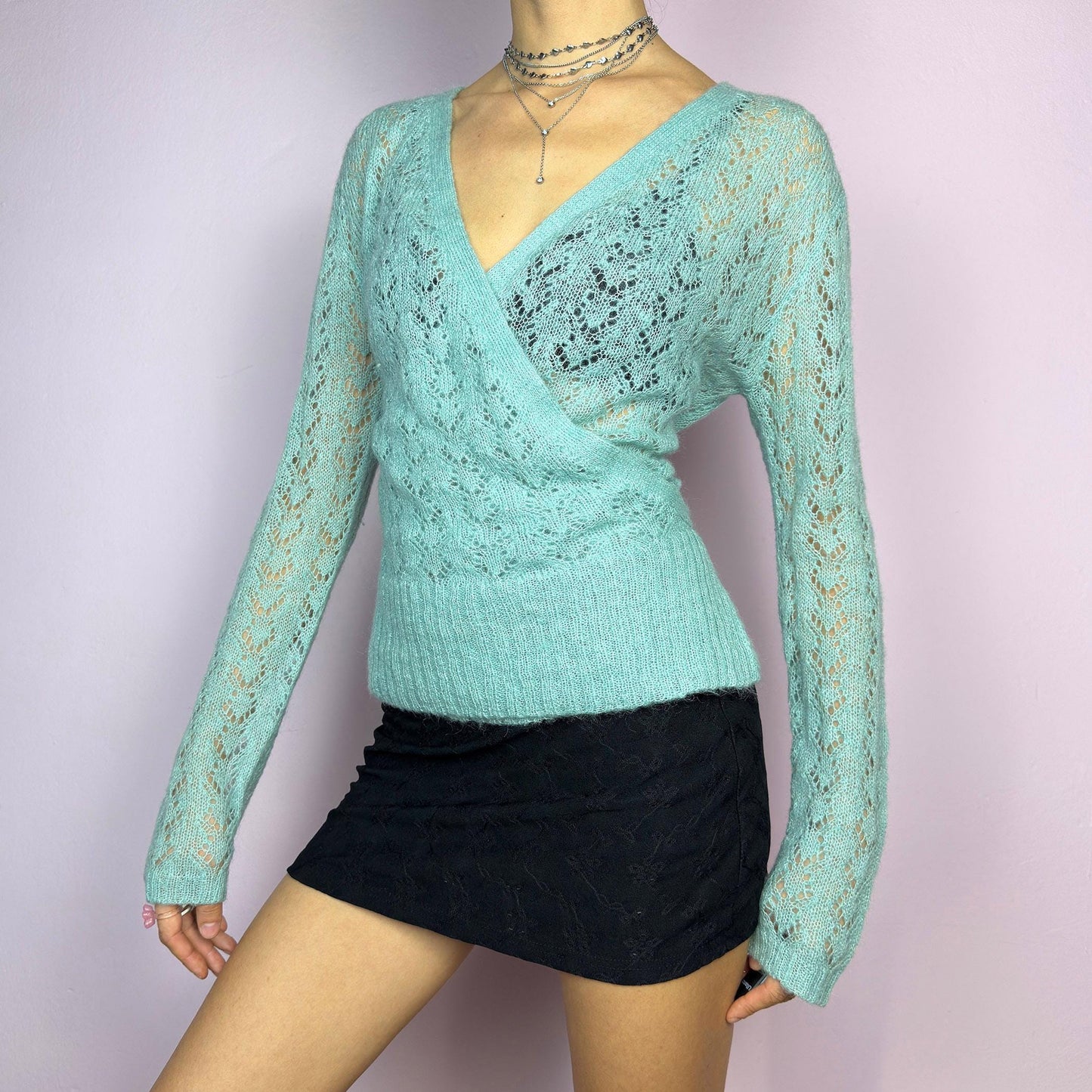 The Y2K Blue Wrap Tie Cardigan is a soft and delicate vintage 2000s piece perfect for layering. Made from a cozy open-knit fabric in a dreamy pastel blue, this cardigan features a wrap-style front with a fitted waist and long sleeve. adult world shop