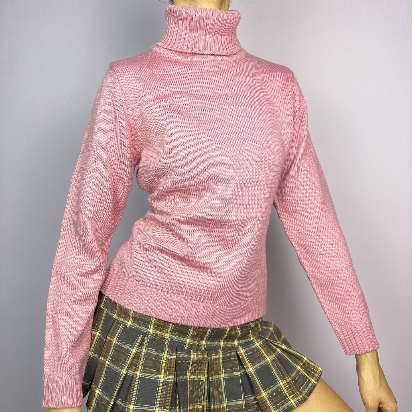 This Y2K Pink Turtleneck Sweater is a cozy 2000s essential with a minimalist vintage aesthetic. Crafted from a soft, knit fabric in a muted pastel pink, it features a classic high turtleneck, a fitted silhouette for a flattering look and long sleeves with ribbed cuffs. Ideal for casual or preppy winter styles. adult world shop