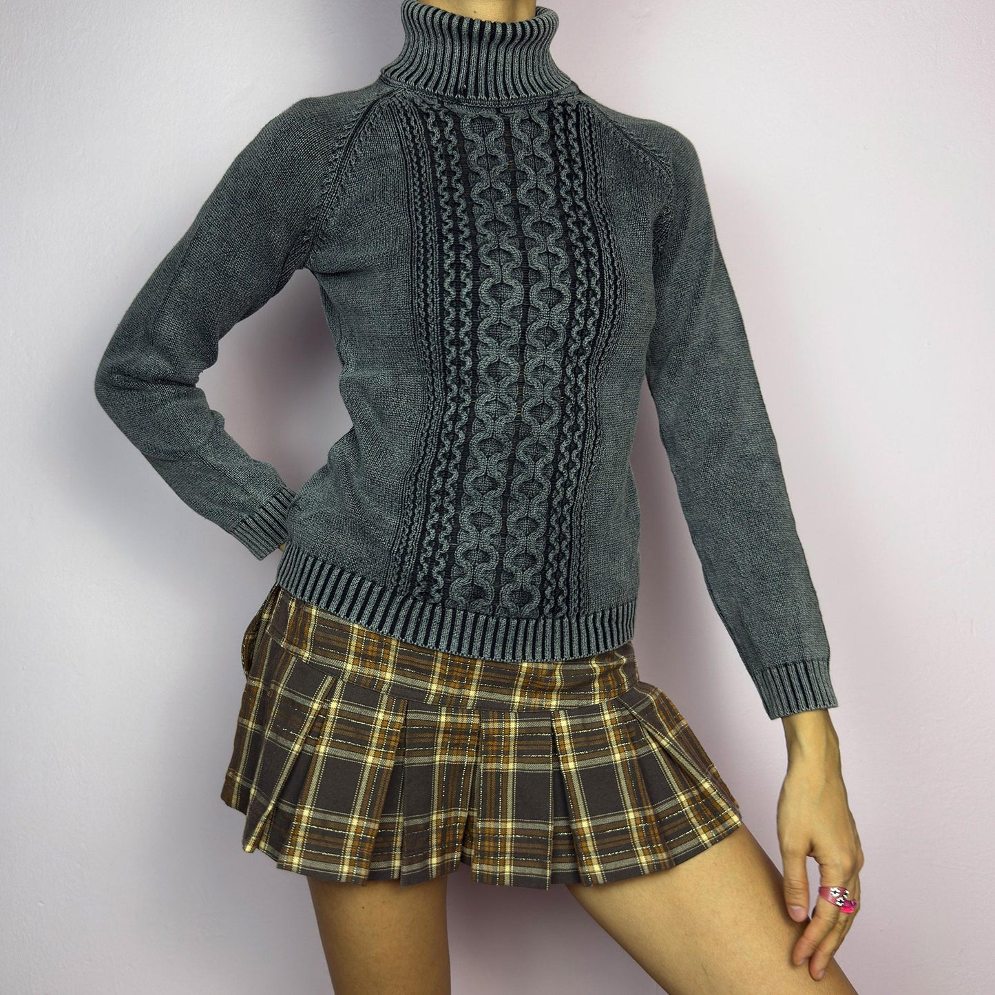 The Y2K Washed Gray Turtleneck Sweater is a vintage 2000s piece, featuring a slightly faded gray tone for a worn-in, effortless look. Designed with an intricate cable knit pattern on the front, ribbed cuffs, and a thick turtleneck, it offers both warmth and style. Ideal for preppy, academia, or casual winter outfits. adult world shop