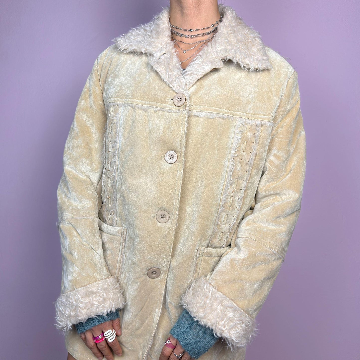 The Y2K Beige Faux Fur Suede Jacket is a vintage 2000s cozy outerwear piece featuring a soft faux suede finish in a beige tone, a faux shearling-lined collar and cuffs for added warmth, a button-front closure and pockets. adult world shop