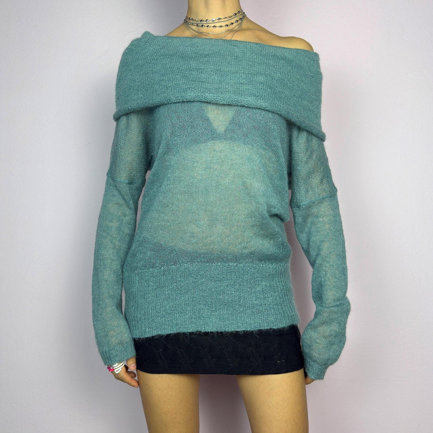 The Y2K Blue Off-Shoulder Sweater is a vintage 2000s cozy and comfy piece made from a mohair, wool, and nylon blend. This soft, semi-sheer sweater features a folded off-shoulder neckline and a muted blue hue. adult world shop