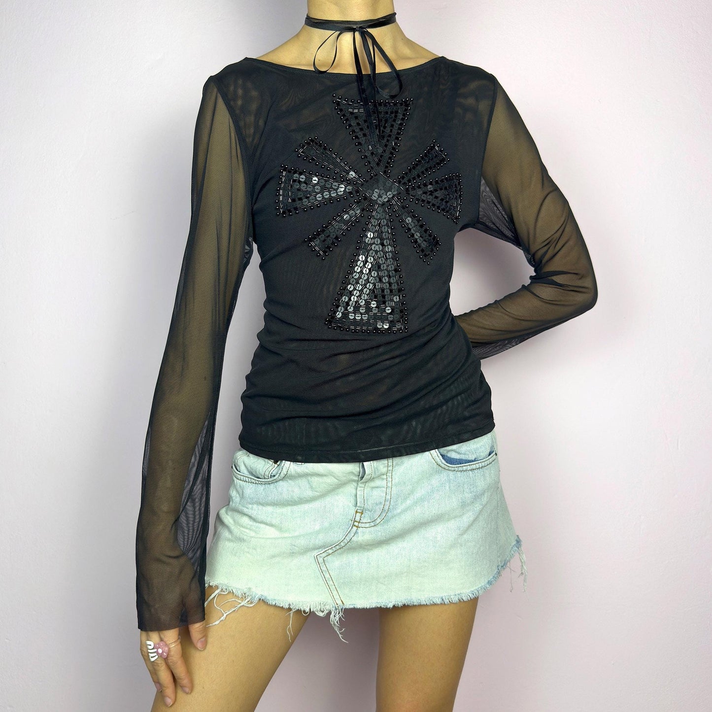 The Y2K Black Embellished Mesh Top is a statement vintage 2000s piece. This sheer top features a bold black sequin and bead embellishment in a striking cross pattern on the front. The lightweight mesh fabric and long sleeves. adult world shop