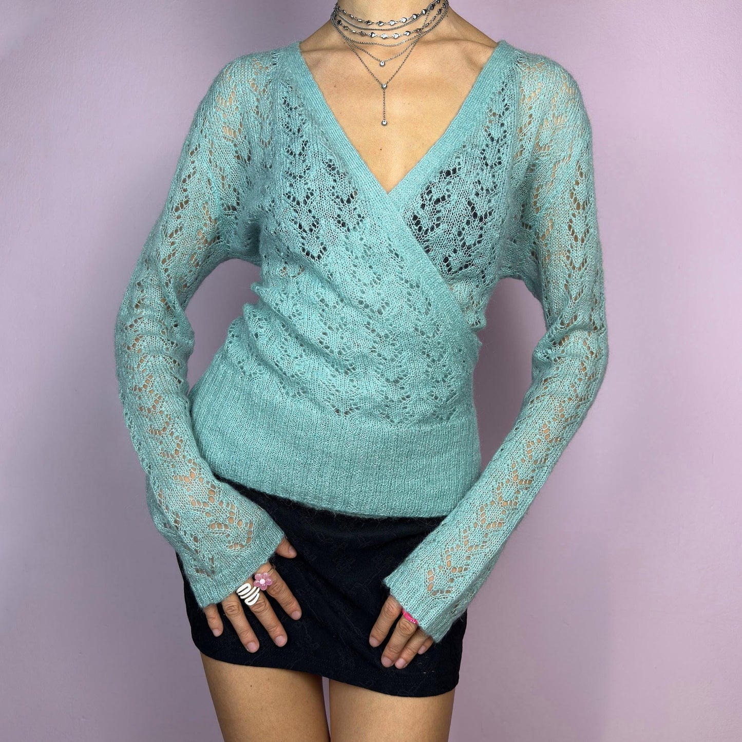 The Y2K Blue Wrap Tie Cardigan is a soft and delicate vintage 2000s piece perfect for layering. Made from a cozy open-knit fabric in a dreamy pastel blue, this cardigan features a wrap-style front with a fitted waist and long sleeve. adult world shop
