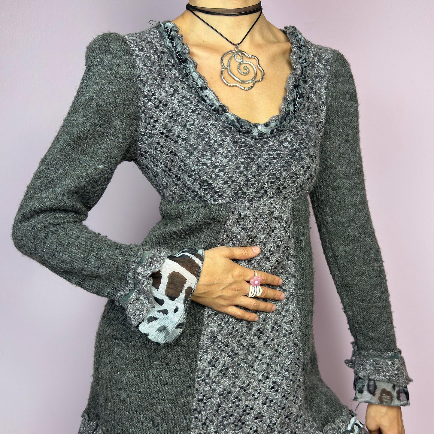 The Y2K Gray Knit Mini Dress is a vintage 2000s piece featuring a patchwork knit design with ruffle trim details. With a fitted bust and flared hem, this dress has a romantic and whimsical aesthetic. The long sleeves add a cozy. adult world shop