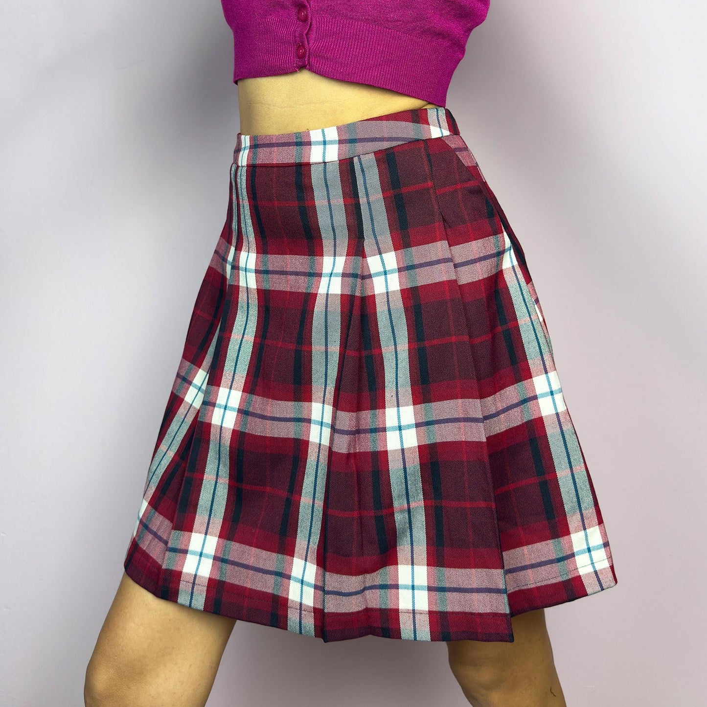 The Y2K Red Plaid Pleated Mini Skirt is a vintage 2000s essential featuring a structured pleated design in a bold red, navy, and white plaid pattern. Made from a woven fabric, it’s perfect for preppy, punk, or casual outfits. adult world shop