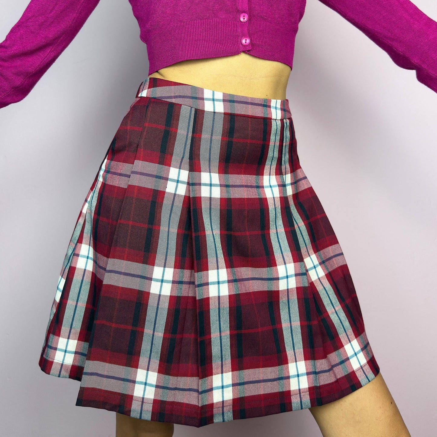 The Y2K Red Plaid Pleated Mini Skirt is a vintage 2000s essential featuring a structured pleated design in a bold red, navy, and white plaid pattern. Made from a woven fabric, it’s perfect for preppy, punk, or casual outfits. adult world shop