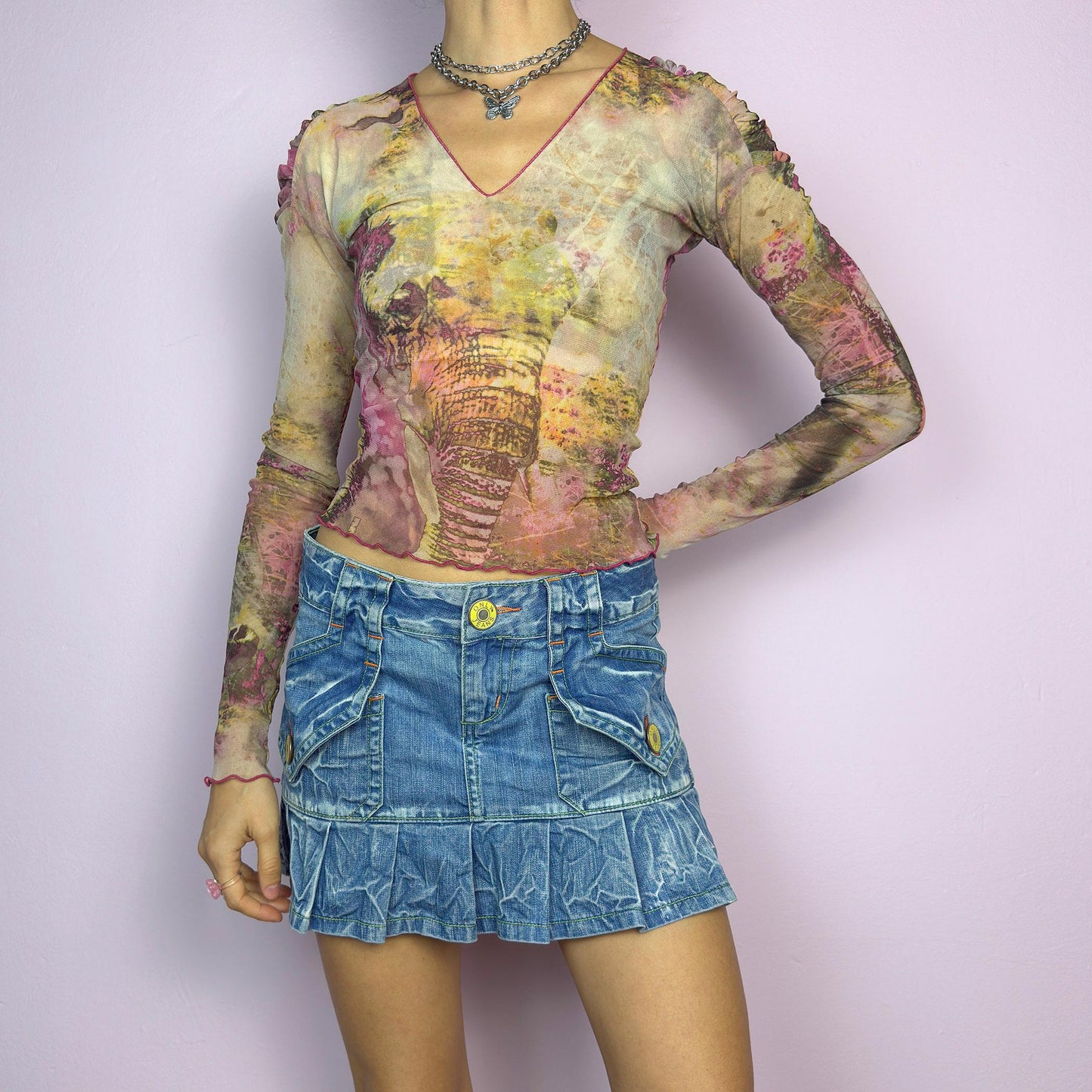 The Y2K Pleated Mini Denim Skirt is a vintage 2000s piece featuring a pleated hem and cargo-style pockets with button details for a playful, utilitarian touch. Crafted from washed blue denim with contrast stitching. adult world shop