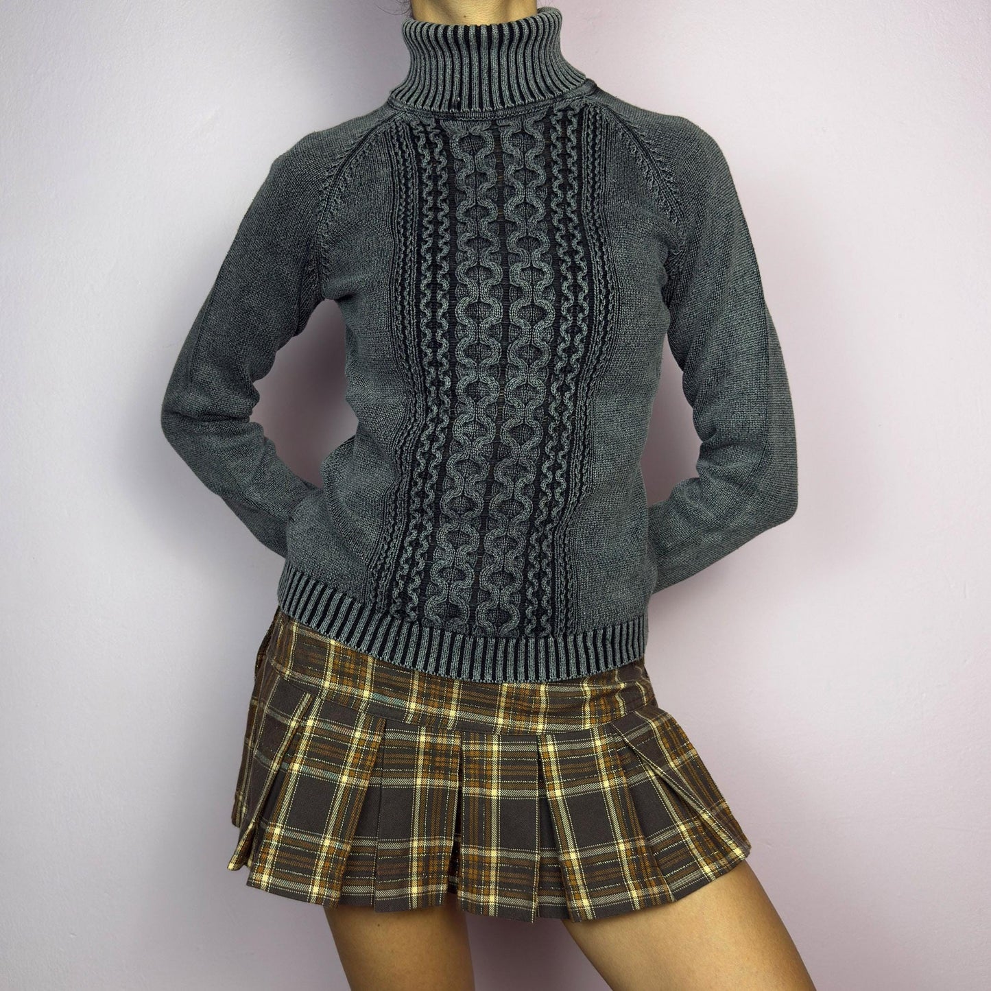 The Y2K Washed Gray Turtleneck Sweater is a vintage 2000s piece, featuring a slightly faded gray tone for a worn-in, effortless look. Designed with an intricate cable knit pattern on the front, ribbed cuffs, and a thick turtleneck, it offers both warmth and style. Ideal for preppy, academia, or casual winter outfits. adult world shop