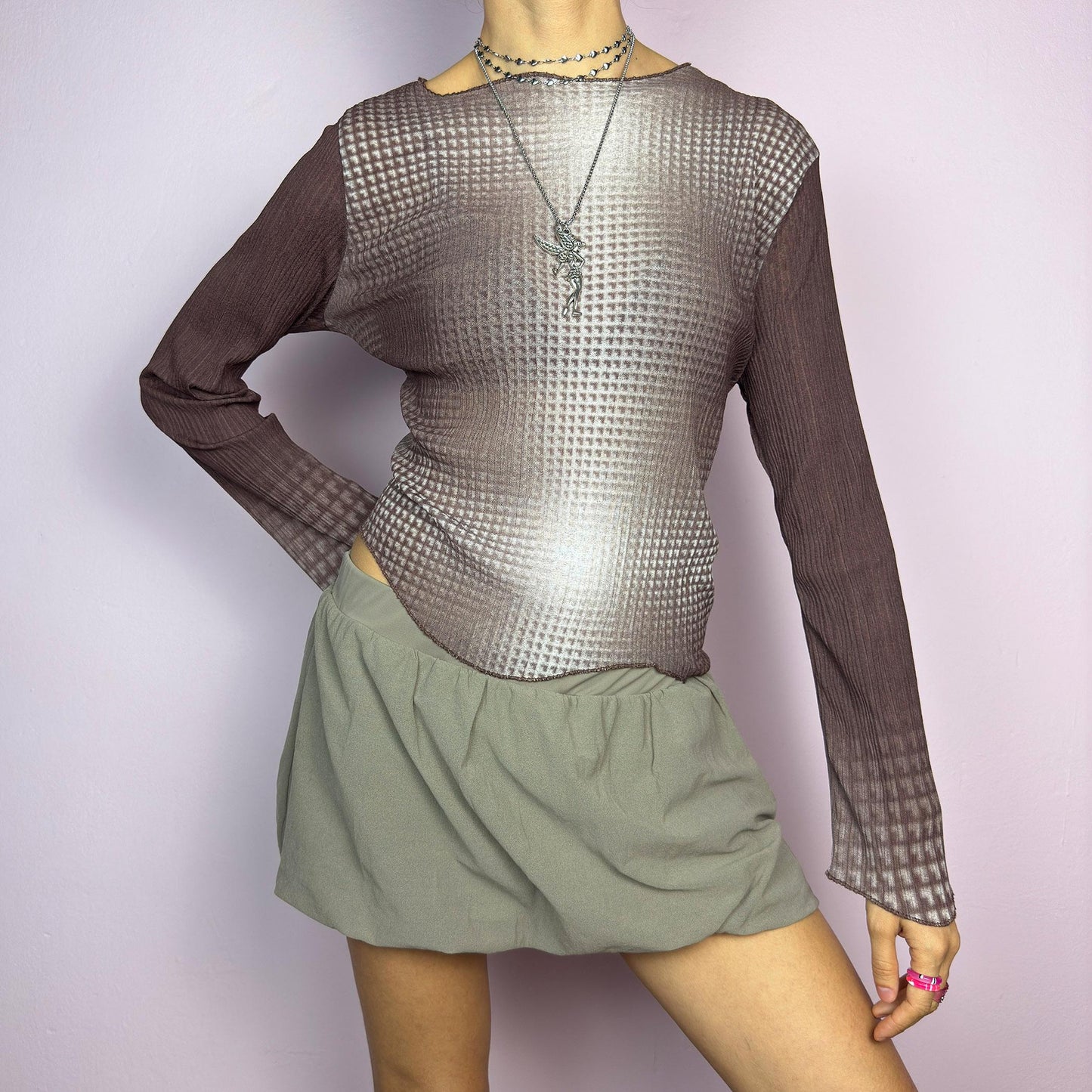 The Y2K Brown Ombre Gradient Top is a vintage 2000s semi-sheer stretchy top featuring a unique ombre gradient print that fades from deep brown to a soft beige. Designed with a subtle asymmetric cut, ribbed texture, and long sleeves, this statement piece adds a futuristic yet earthy touch to casual and streetwear outfits. Perfect for a sleek, edgy look. adult world shop