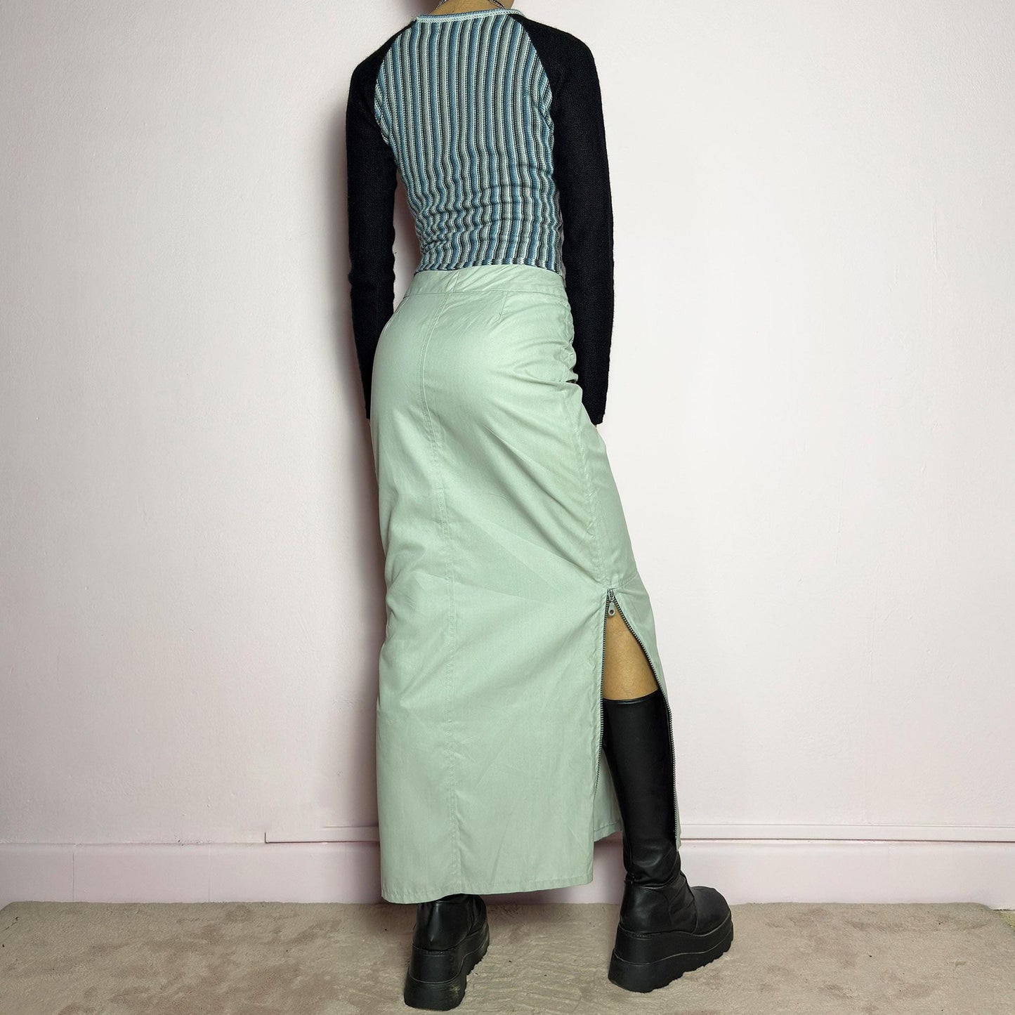 The Y2K Light Gray Maxi Skirt is a vintage 2000s piece with a sleek, futuristic aesthetic. Featuring a structured fit, and a high-rise waist, this skirt is designed for a modern, minimal look. Made from lightweight fabric, it offers a flattering silhouette with dual side zipper slits for adjustable styling. Perfect for casual, streetwear, or cyber-inspired avant-garde outfits. adult world shop