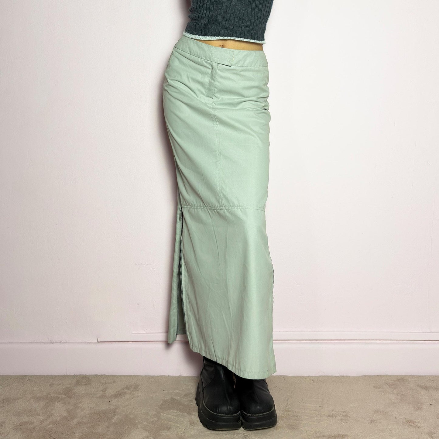 The Y2K Light Gray Maxi Skirt is a vintage 2000s piece with a sleek, futuristic aesthetic. Featuring a structured fit, and a high-rise waist, this skirt is designed for a modern, minimal look. Made from lightweight fabric, it offers a flattering silhouette with dual side zipper slits for adjustable styling. Perfect for casual, streetwear, or cyber-inspired avant-garde outfits. adult world shop