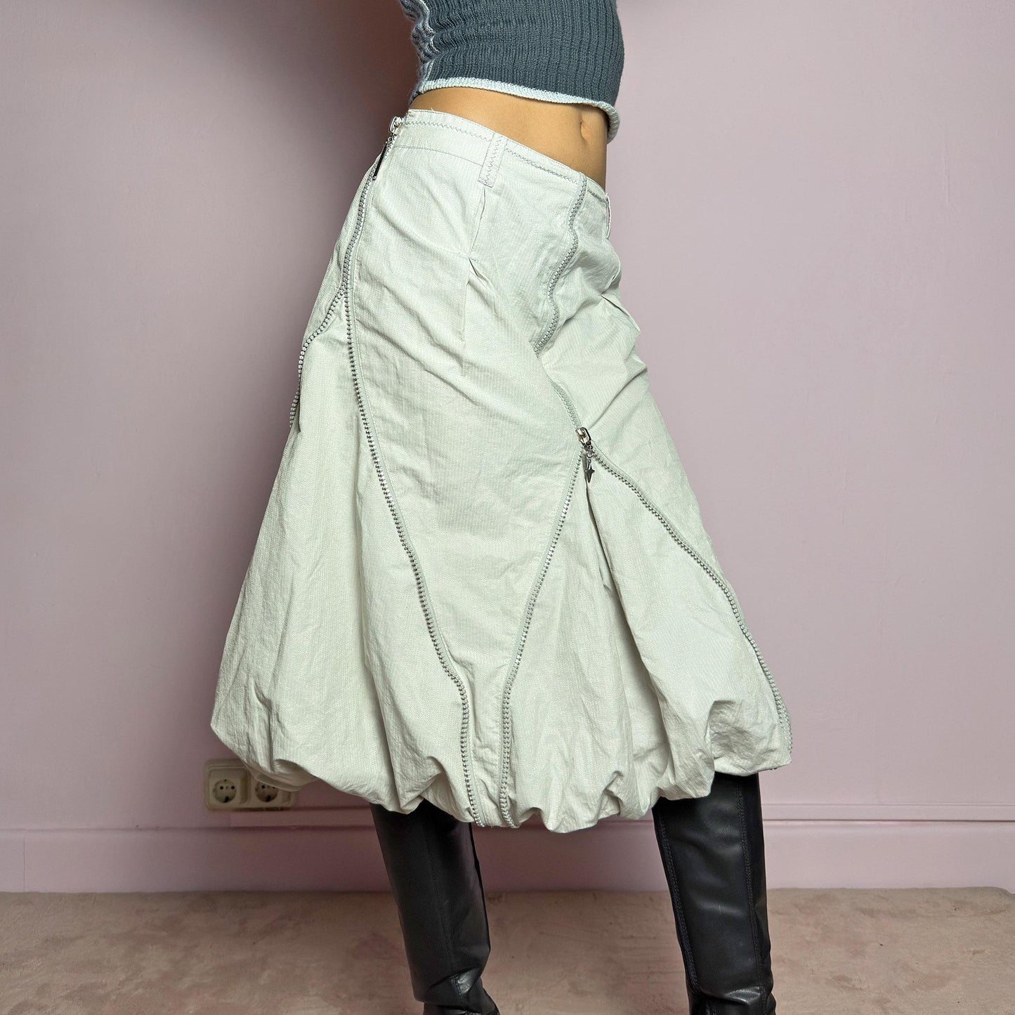 The Y2K Gray Bubble Midi Skirt is a futuristic statement 2000s piece featuring a voluminous bubble silhouette with multiple zipper details that create a dynamic, adjustable shape. Designed with a structured high-rise fit, and a side zipper closure, this skirt is perfect for bold streetwear outfits. adult world shop