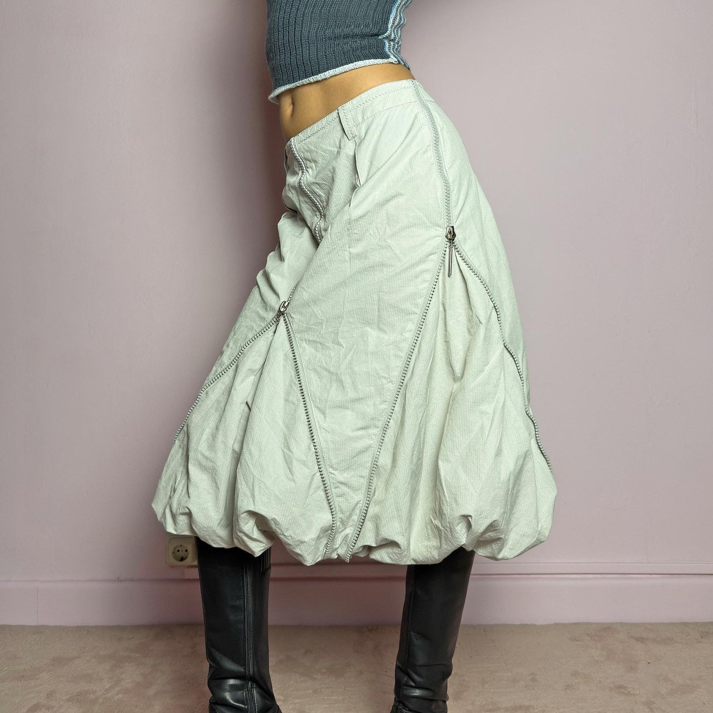 The Y2K Gray Bubble Midi Skirt is a futuristic statement 2000s piece featuring a voluminous bubble silhouette with multiple zipper details that create a dynamic, adjustable shape. Designed with a structured high-rise fit, and a side zipper closure, this skirt is perfect for bold streetwear outfits. adult world shop