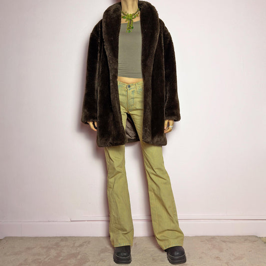 The Vintage 90s Brown Faux Fur Coat is a luxurious and cozy statement piece. Featuring a soft plush texture, and a deep chocolate brown hue, this coat exudes effortless elegance and warmth. Designed with a relaxed fit, pockets, and a hidden hook closure, it's perfect for layering over casual or dressed-up winter outfits. Made in Spain. adult world shop