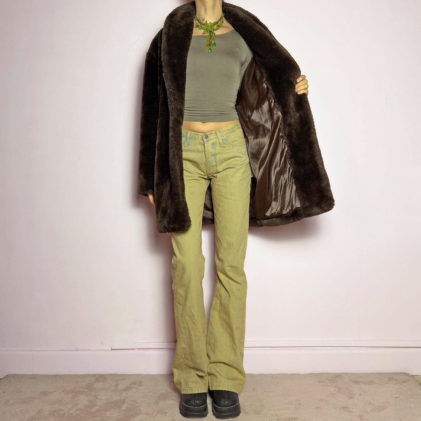 The Vintage 90s Brown Faux Fur Coat is a luxurious and cozy statement piece. Featuring a soft plush texture, and a deep chocolate brown hue, this coat exudes effortless elegance and warmth. Designed with a relaxed fit, pockets, and a hidden hook closure, it's perfect for layering over casual or dressed-up winter outfits. Made in Spain. adult world shop